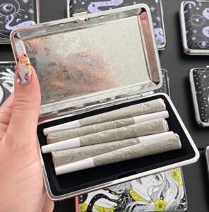 The Lovers joint case by Cannabitches, open metal case showing eye and roses art