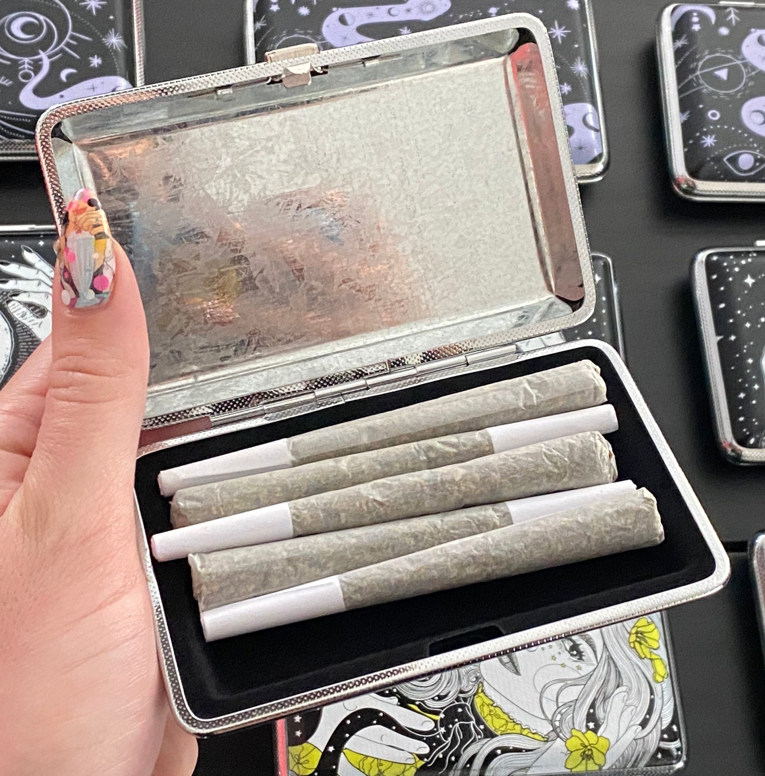 The Lovers joint case by Cannabitches, open metal case showing eye and roses art
