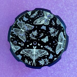 Luna moths and butterflies black herb grinder by Cannabitches on purple backdrop