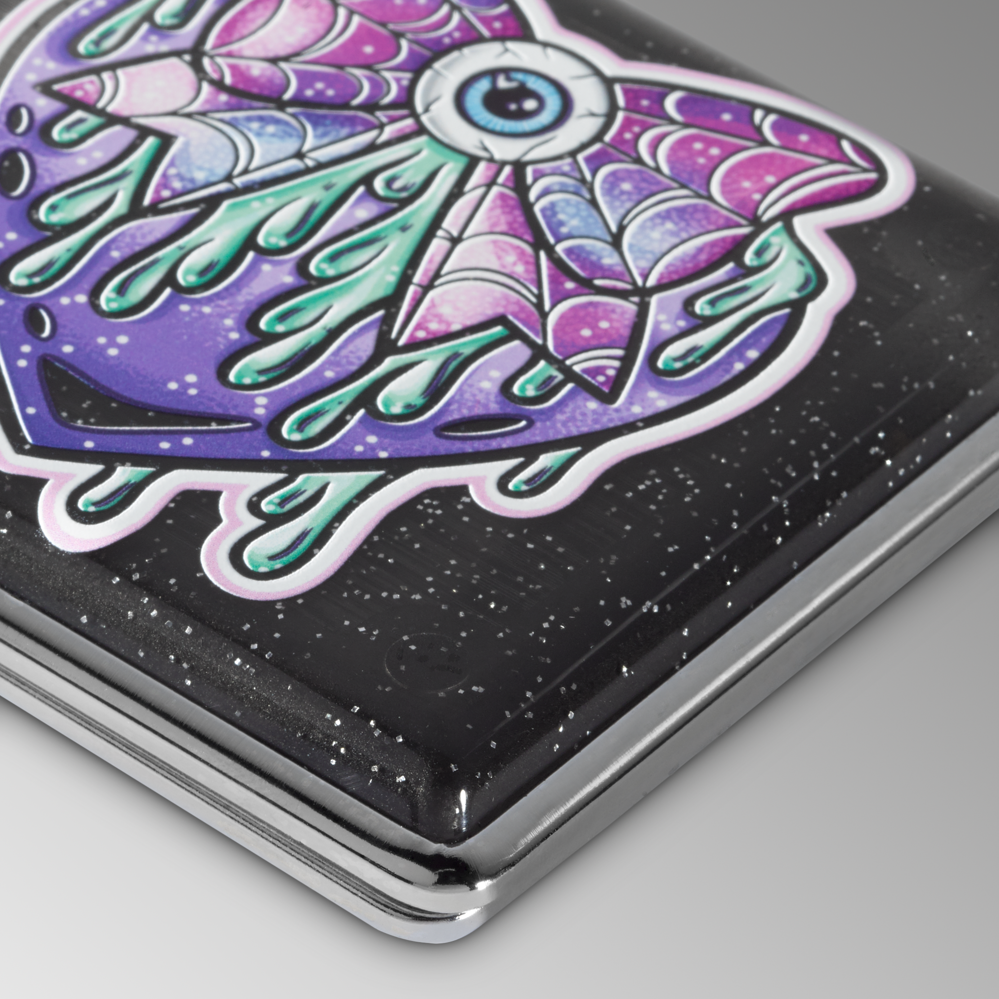 Black Sparkle Eye Love You to Death stash case, close-up of the purple winged eye